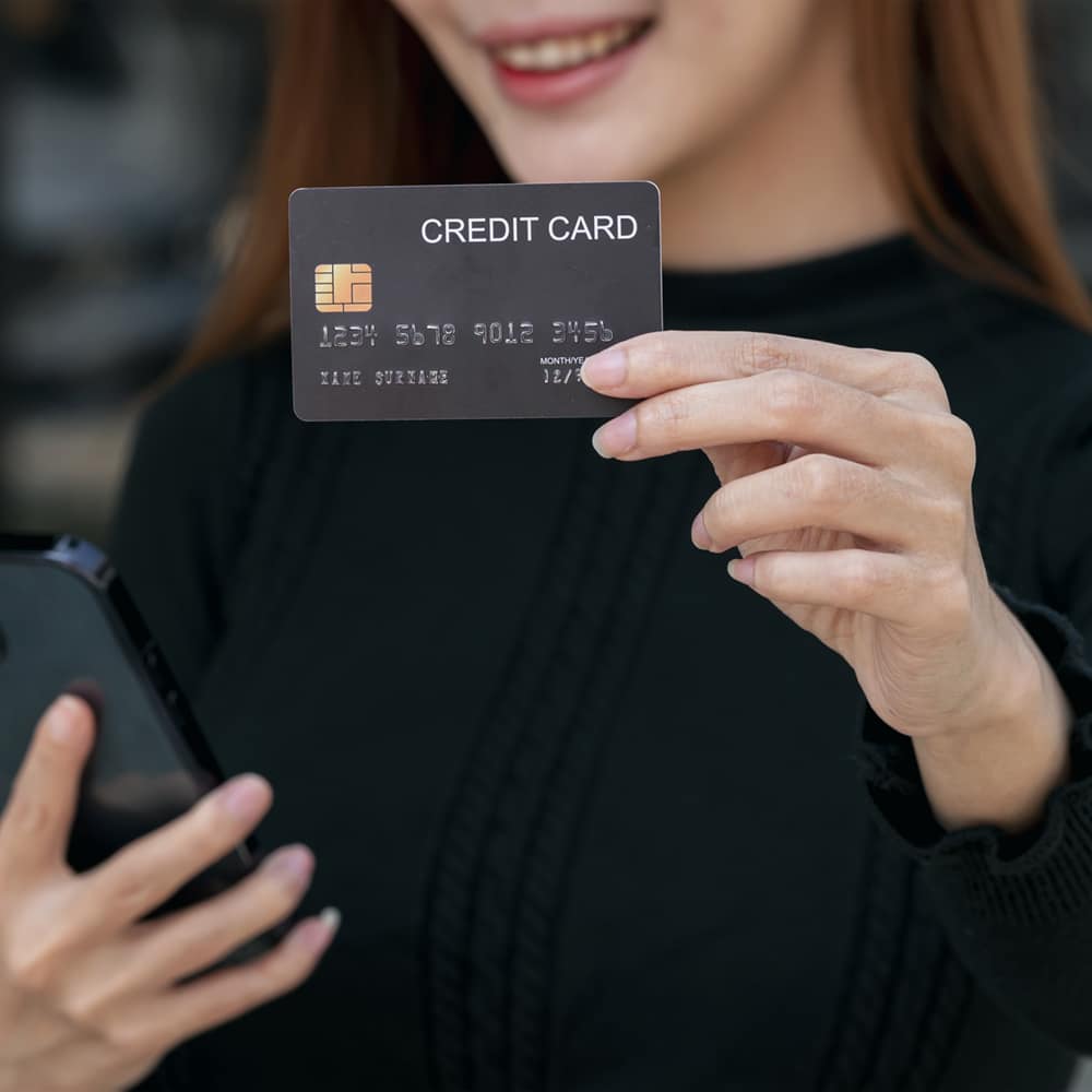 asian woman holding and presenting the credit card for online sh