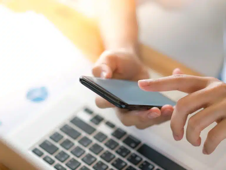 business woman hand with financial charts and mobile phone over