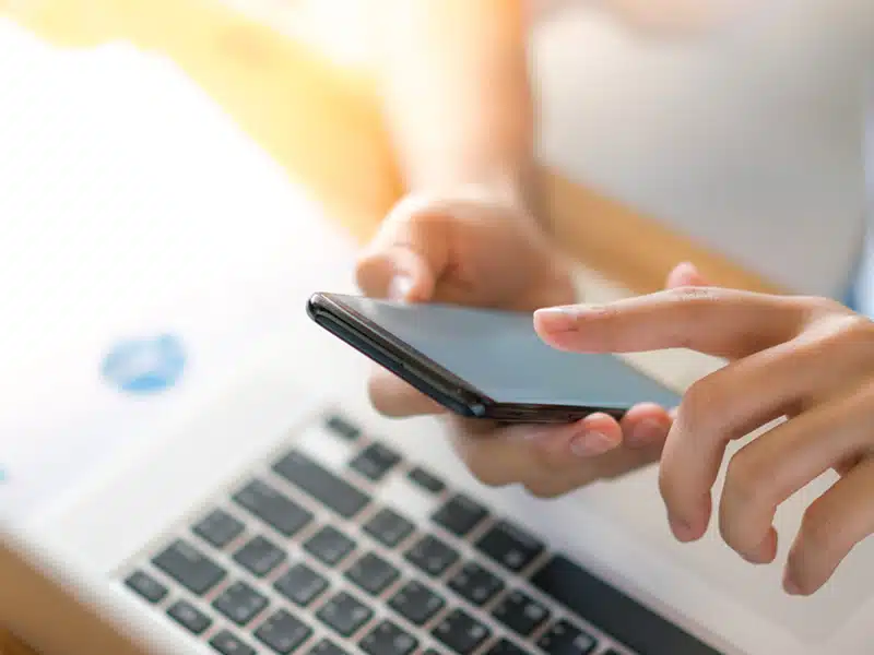 business woman hand with financial charts and mobile phone over