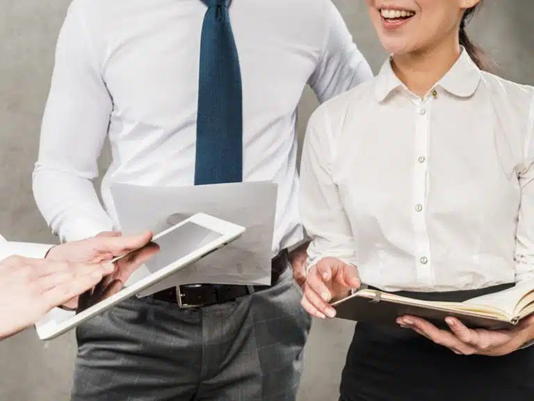 close up businesspeople working together against grey wall