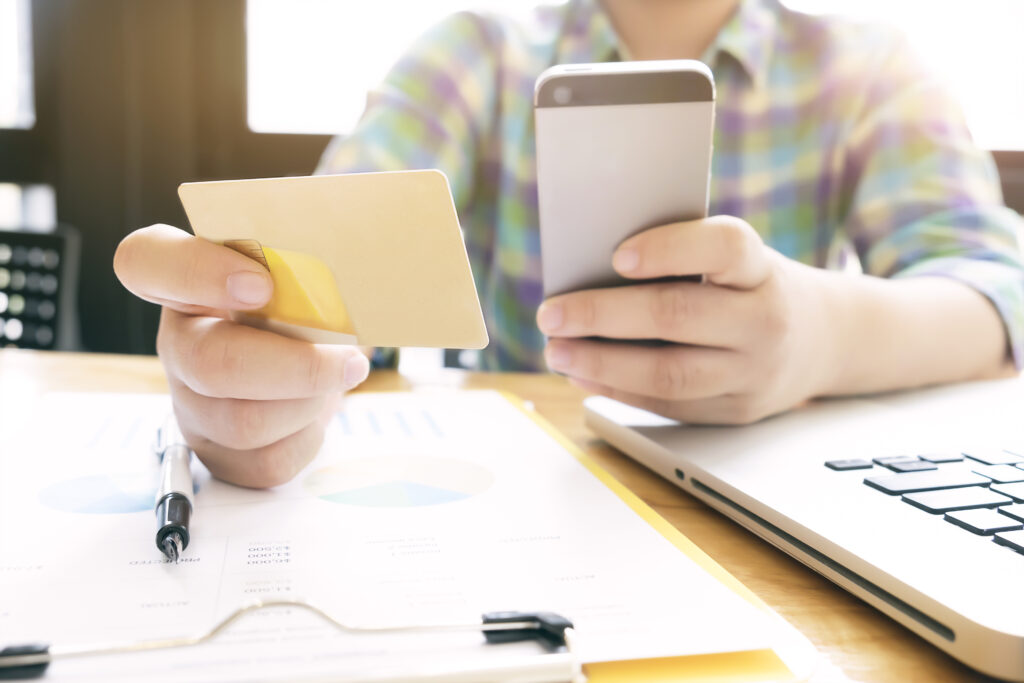 woman using laptop and mobile phone to online shopping and pay b