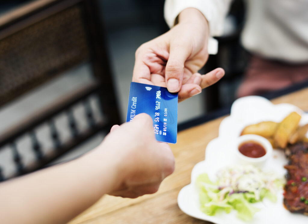 woman paying lunch with credit card at restaurant