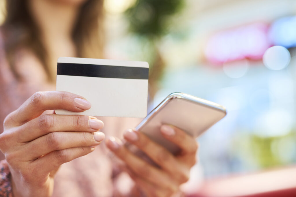 woman using mobile phone and credit card during online shopping